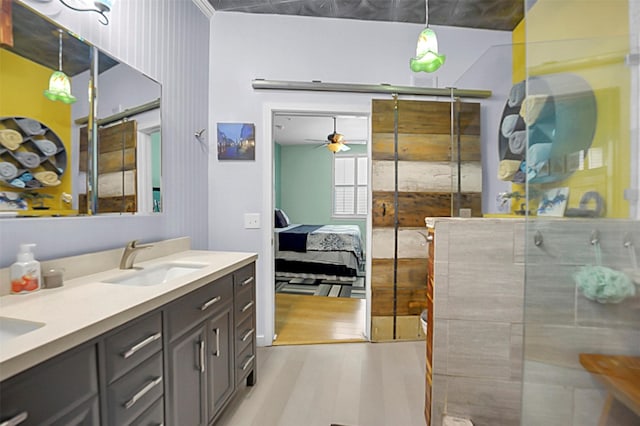 full bath featuring double vanity, a sink, ensuite bath, wood finished floors, and walk in shower