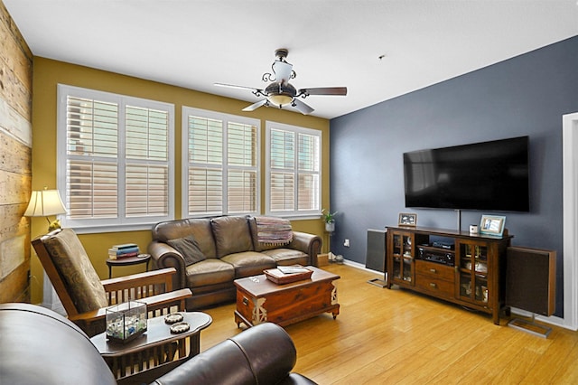 living area with ceiling fan, light wood-style flooring, and baseboards