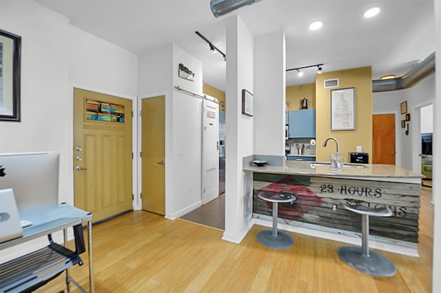 interior space with recessed lighting, rail lighting, visible vents, a sink, and wood finished floors