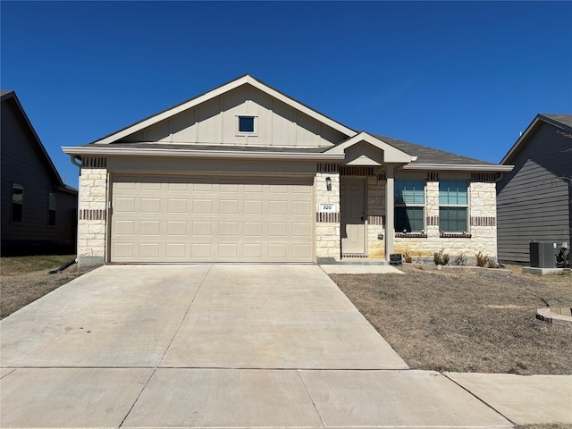 ranch-style house with board and batten siding, a garage, cooling unit, stone siding, and driveway