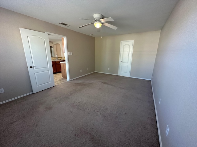 unfurnished room with a ceiling fan, carpet, visible vents, and baseboards