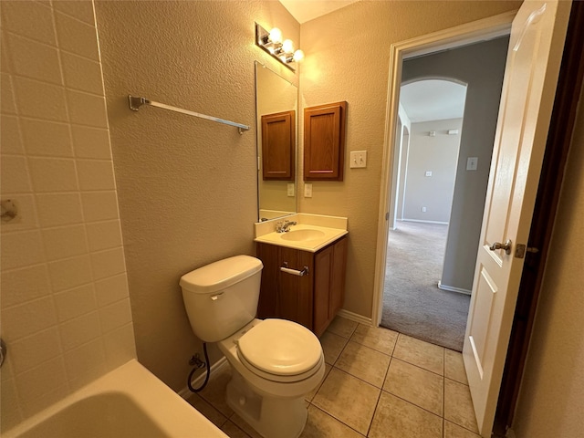 full bathroom featuring a textured wall, toilet, vanity, baseboards, and tile patterned floors