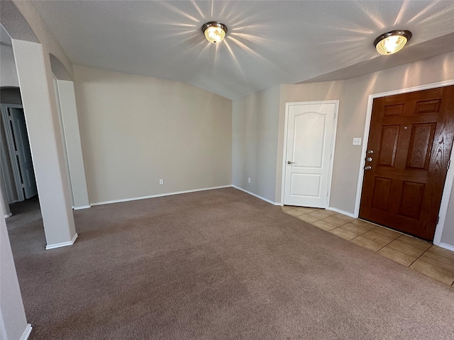 carpeted foyer with baseboards and tile patterned floors