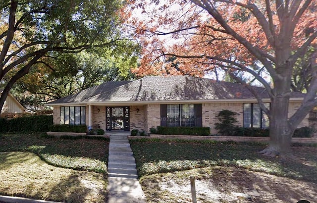 single story home with a front lawn and brick siding