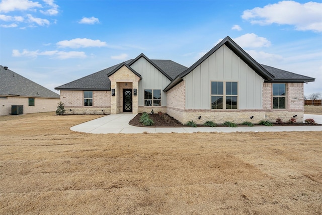 modern farmhouse with roof with shingles, brick siding, and board and batten siding