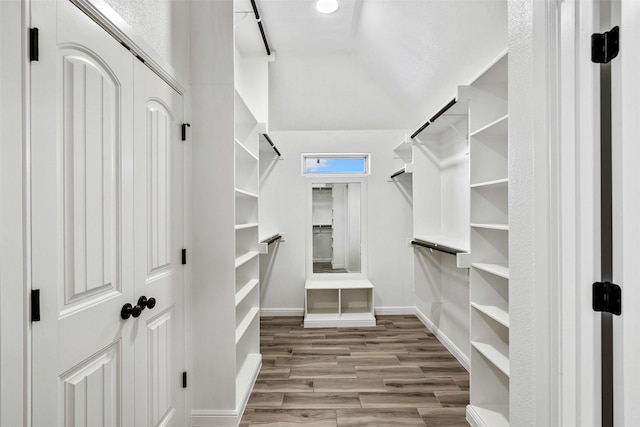 spacious closet with vaulted ceiling and wood finished floors