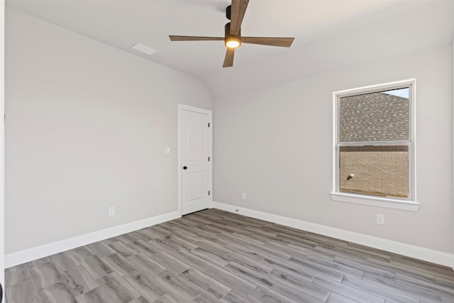 unfurnished room featuring lofted ceiling, ceiling fan, baseboards, and wood finished floors