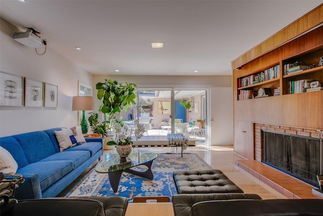 living room featuring light wood-style floors and a fireplace with raised hearth