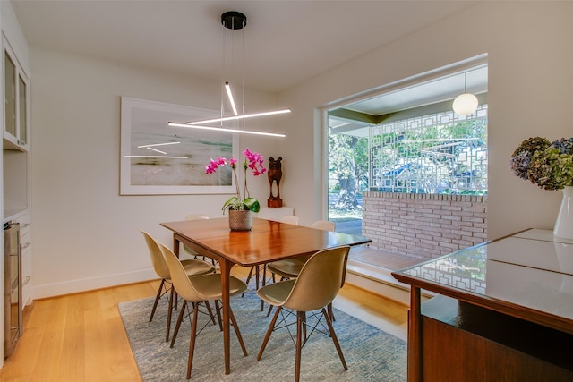 dining area with baseboards and light wood finished floors