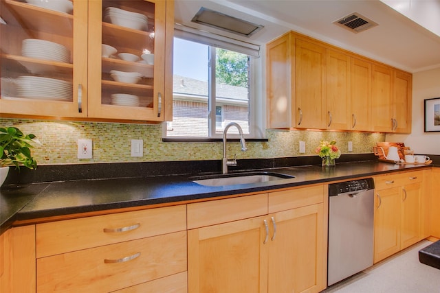 kitchen with a sink, visible vents, stainless steel dishwasher, dark countertops, and glass insert cabinets