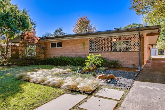 view of front of house featuring brick siding and a front yard