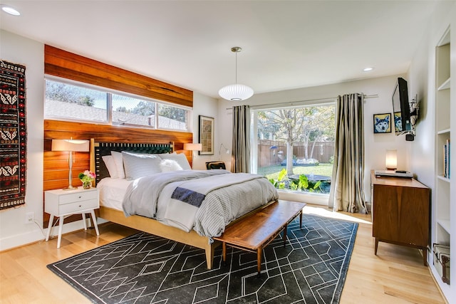 bedroom featuring baseboards, light wood finished floors, and recessed lighting