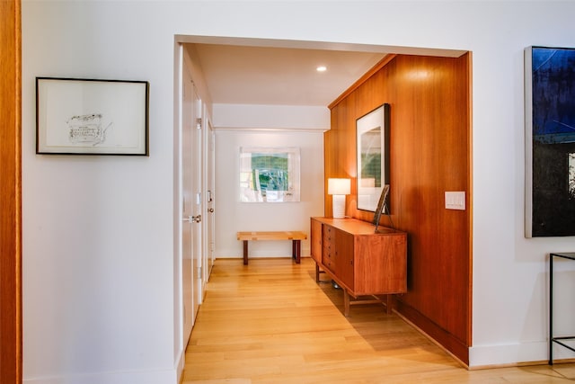 corridor with light wood-style flooring and baseboards