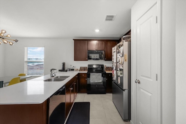 kitchen featuring light countertops, visible vents, light tile patterned flooring, a sink, and black appliances