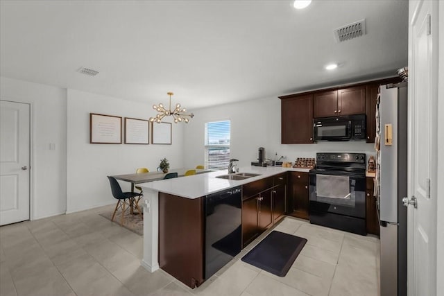 kitchen featuring pendant lighting, light countertops, visible vents, a sink, and black appliances