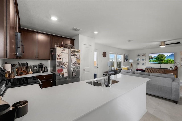 kitchen featuring dark brown cabinetry, range with electric stovetop, visible vents, light countertops, and freestanding refrigerator