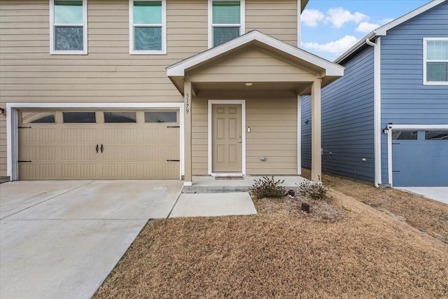 entrance to property featuring a garage and concrete driveway