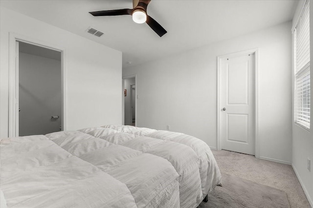 bedroom with a ceiling fan, light colored carpet, visible vents, and baseboards