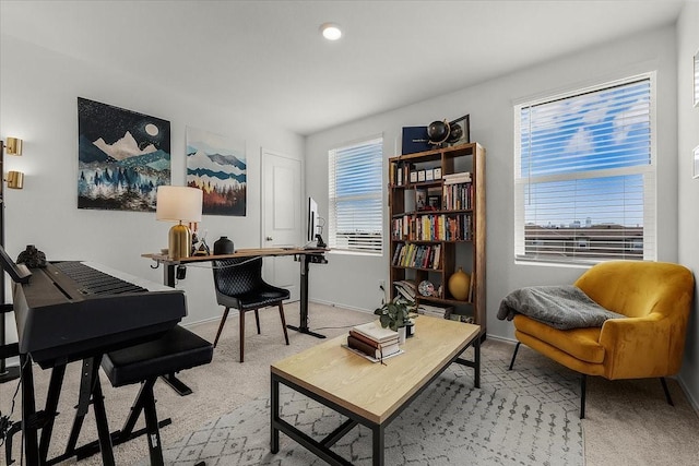 living area with light carpet, a wealth of natural light, and baseboards