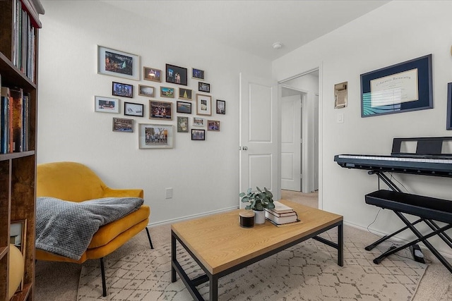 living area featuring baseboards and light colored carpet