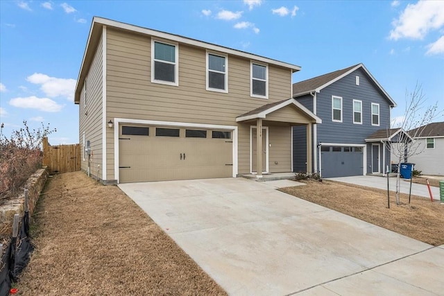 traditional-style house featuring a garage, driveway, and fence