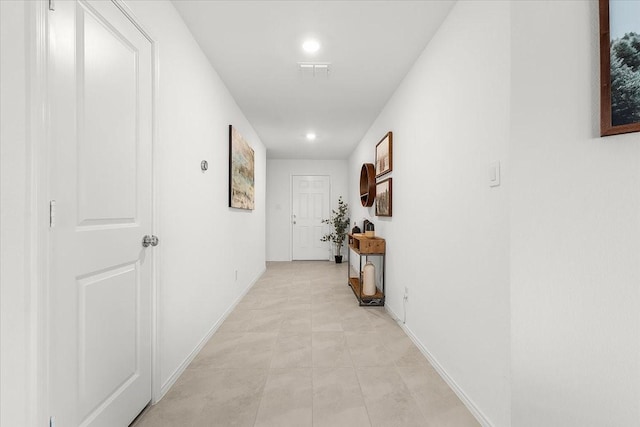 hallway featuring visible vents and baseboards