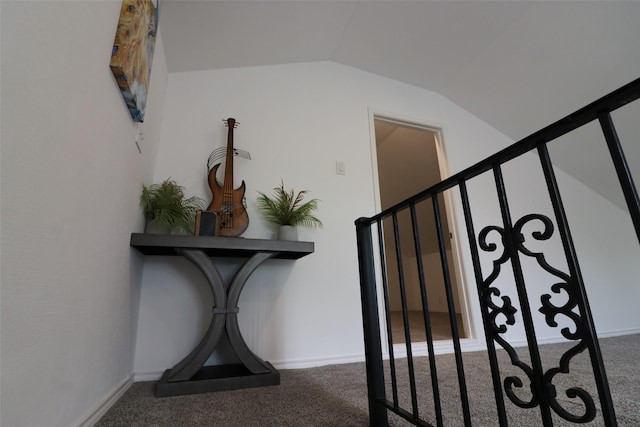 stairway featuring lofted ceiling, carpet flooring, and baseboards