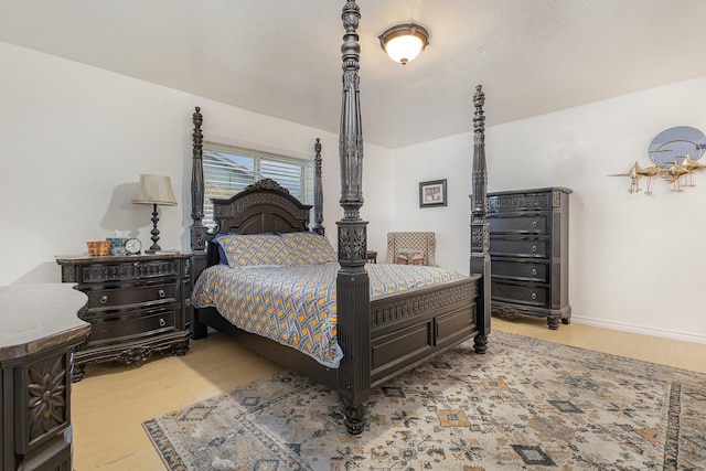 bedroom with baseboards and wood finished floors