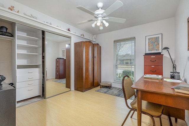 home office with light wood-style flooring and ceiling fan