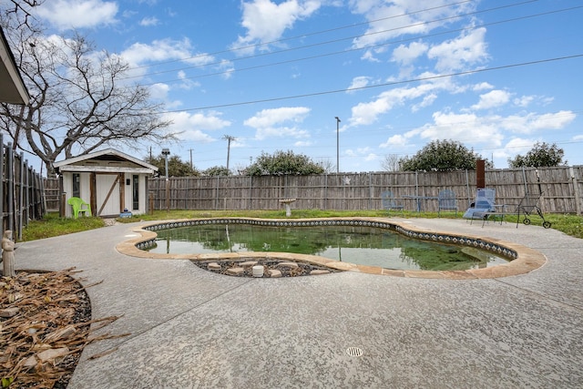 view of pool with a fenced in pool, a patio area, a fenced backyard, and an outdoor structure