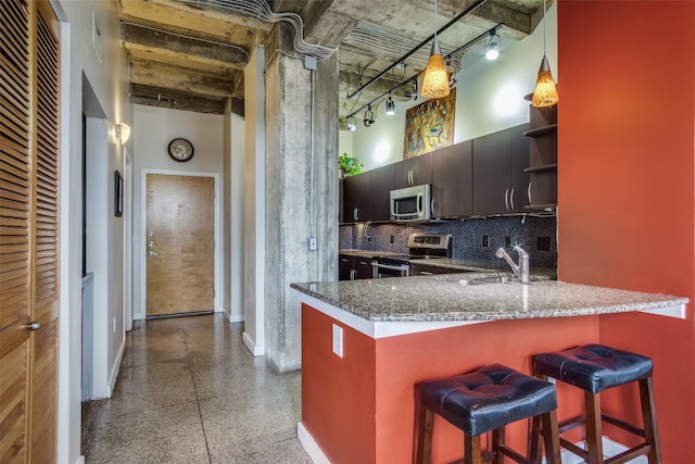 kitchen with dark speckled floor, open shelves, stainless steel appliances, a sink, and a peninsula