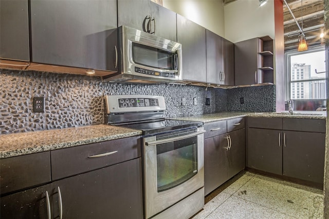 kitchen featuring decorative backsplash, light stone counters, stainless steel appliances, light speckled floor, and a sink