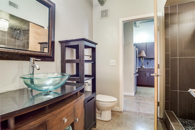 bathroom with baseboards, visible vents, vanity, and toilet