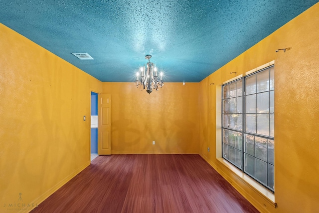 5651 Bretwood Dr, Keithville, LA 71047 - unfurnished dining area with wood finished floors, a textured ceiling, baseboards, a notable chandelier, and visible vents