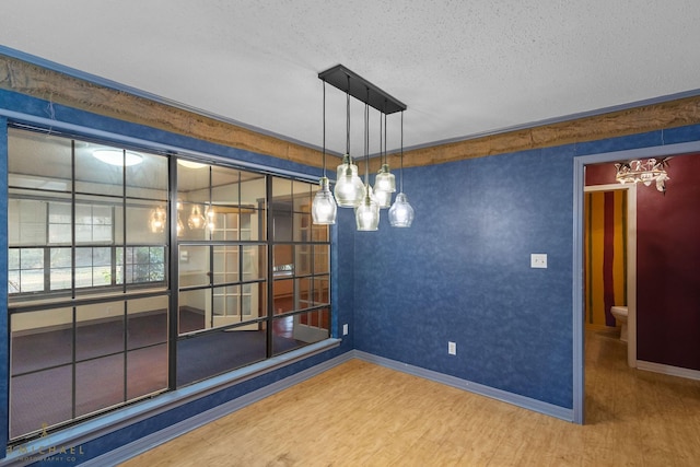 5651 Bretwood Dr, Keithville, LA 71047 - unfurnished room with an inviting chandelier, wood finished floors, a textured ceiling, and baseboards