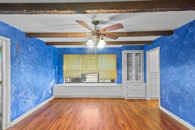 5651 Bretwood Dr, Keithville, LA 71047 - unfurnished room with a ceiling fan, wood finished floors, a textured ceiling, baseboards, and beam ceiling