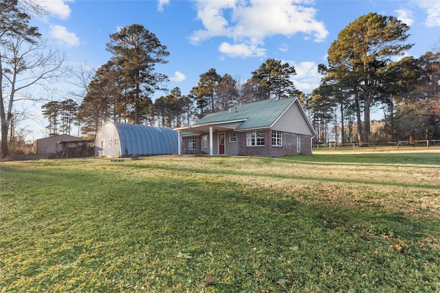 view of front facade with metal roof, a front lawn, and brick siding