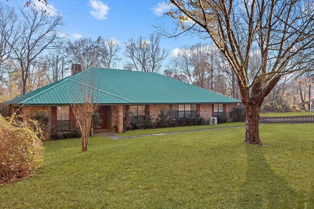 5651 Bretwood Dr, Keithville, LA 71047 - view of front of house featuring brick siding, a chimney, a front lawn, and metal roof