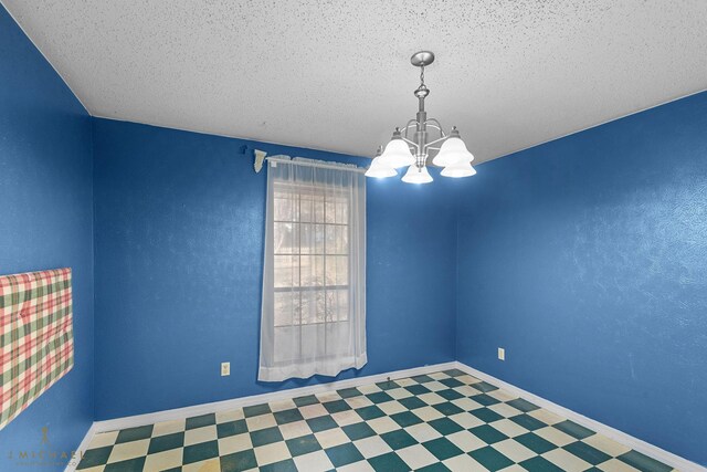 5651 Bretwood Dr, Keithville, LA 71047 - spare room featuring a chandelier, a textured ceiling, tile patterned floors, and baseboards