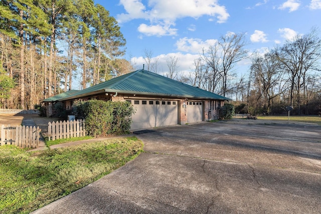 5651 Bretwood Dr, Keithville, LA 71047 - view of side of home featuring fence, a garage, driveway, and metal roof