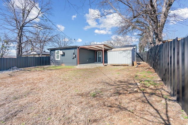 exterior space featuring an outbuilding, a fenced backyard, a patio, and a storage unit