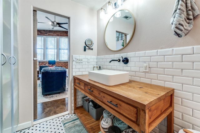 bathroom featuring vanity, tile walls, visible vents, ceiling fan, and wainscoting