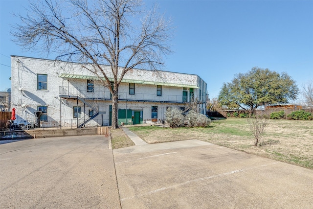 view of front facade with stairs, fence, and a front yard