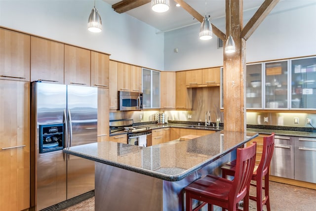 kitchen featuring a kitchen bar, a high ceiling, a sink, beamed ceiling, and appliances with stainless steel finishes