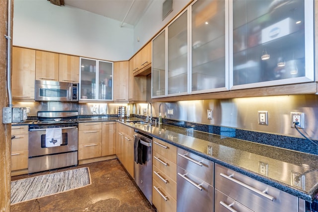 kitchen featuring light brown cabinets, a sink, modern cabinets, and appliances with stainless steel finishes