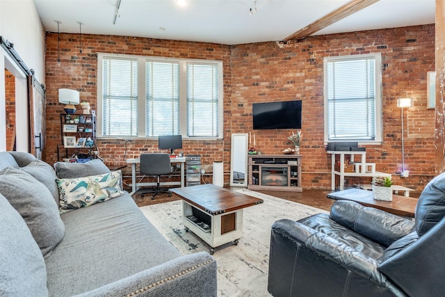 living area featuring a glass covered fireplace and brick wall