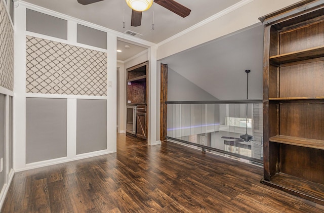 empty room with a ceiling fan, visible vents, ornamental molding, and wood finished floors