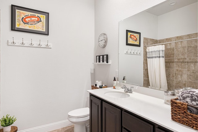 full bathroom with tiled shower, vanity, toilet, and baseboards