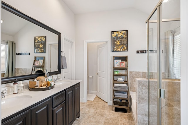 full bath with lofted ceiling, a stall shower, double vanity, and a sink