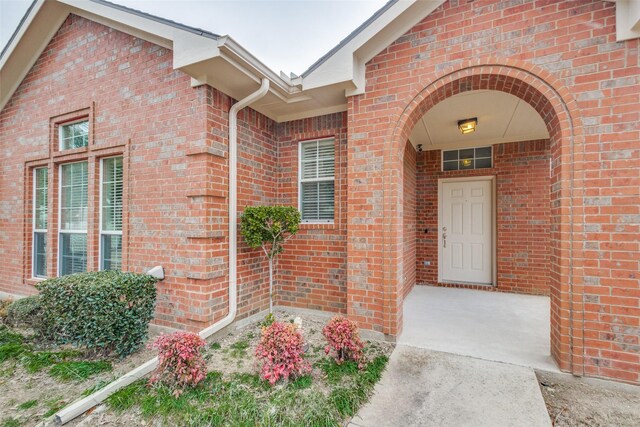 view of exterior entry with brick siding